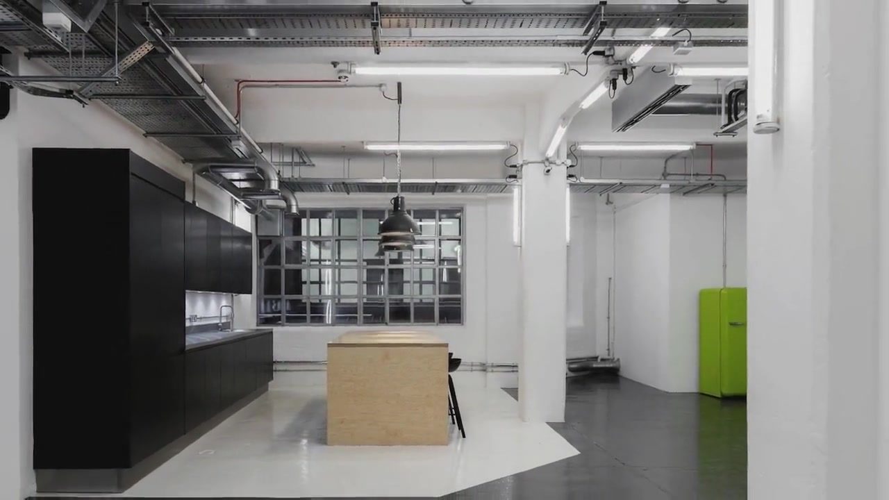 Tea Building workspace fit-out in Shoreditch by Garrity: plywood kitchen island and matt black cabinetry
