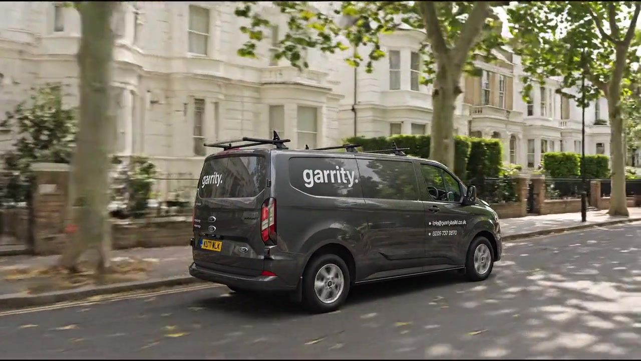 Garrity branded van on a street of white stucco townhouses in London